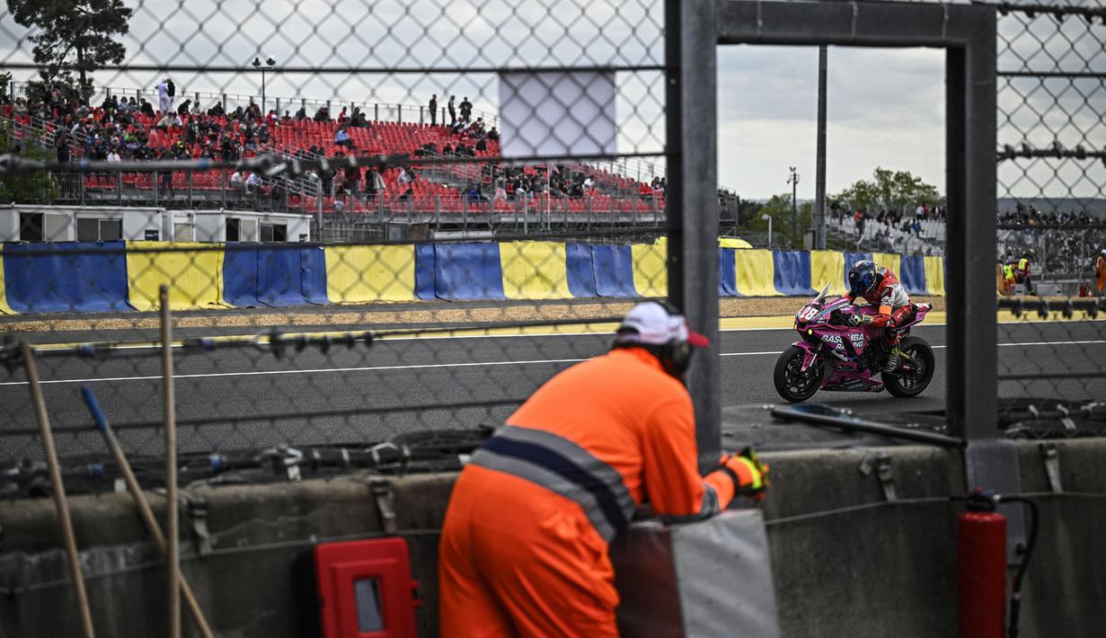 Seorang pmbalap terlihat di antara jendela marshal dalam ajang 24 Hours of Le Mans yang berlangsung di Sirkuit Bugatti, Prancis, 18 April 2026 waktu setempat. (AFP/Julien De Rosa)