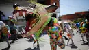 Seorang pria mengenakan kostum dan topeng binatang saat mengikuti perayaan tradisional di Naiguata, Venezuela (31/5). Perayaan tradisional Corpus Christi di kota pesisir Venezuela ini bertujuan untuk memuliakan Tuhan. (AP/Arian Cubillos)