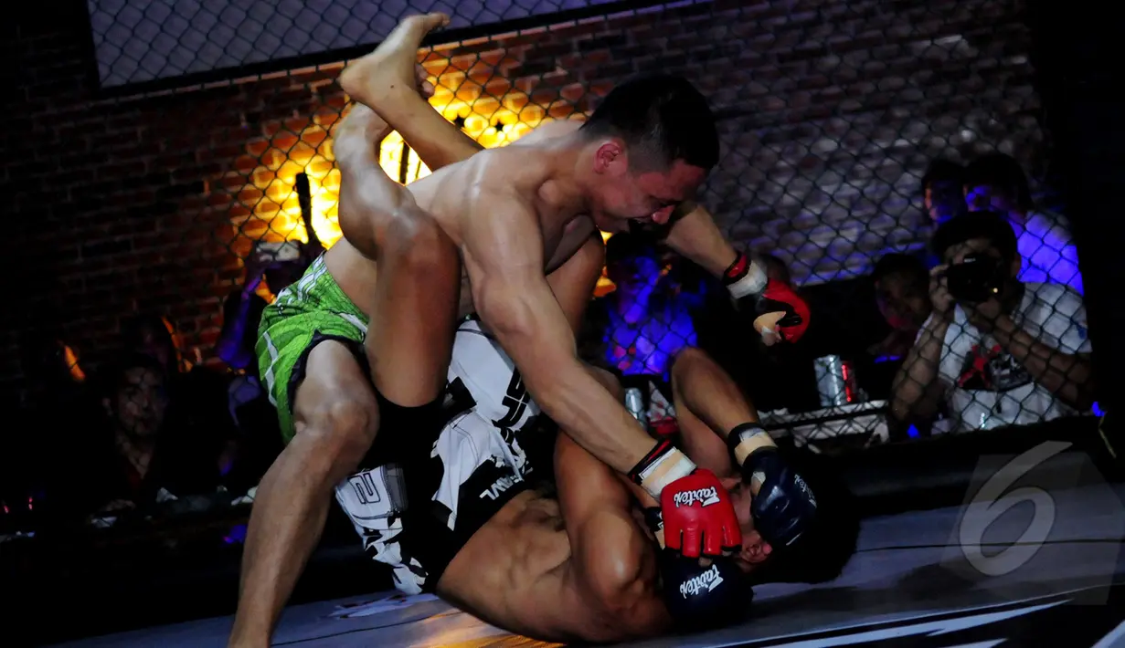 Aksi saling menjatuhkan lawan mewarnai  XXC Championship 2015 yang dihelat di Embrio Markas Cafe, Jakarta, Minggu (12/04/15). XCC Championship 2015 salah satu olah raga bela diri MMA (Mixed Matrial Arts). (Liputan6.com/Faisal R Syam)