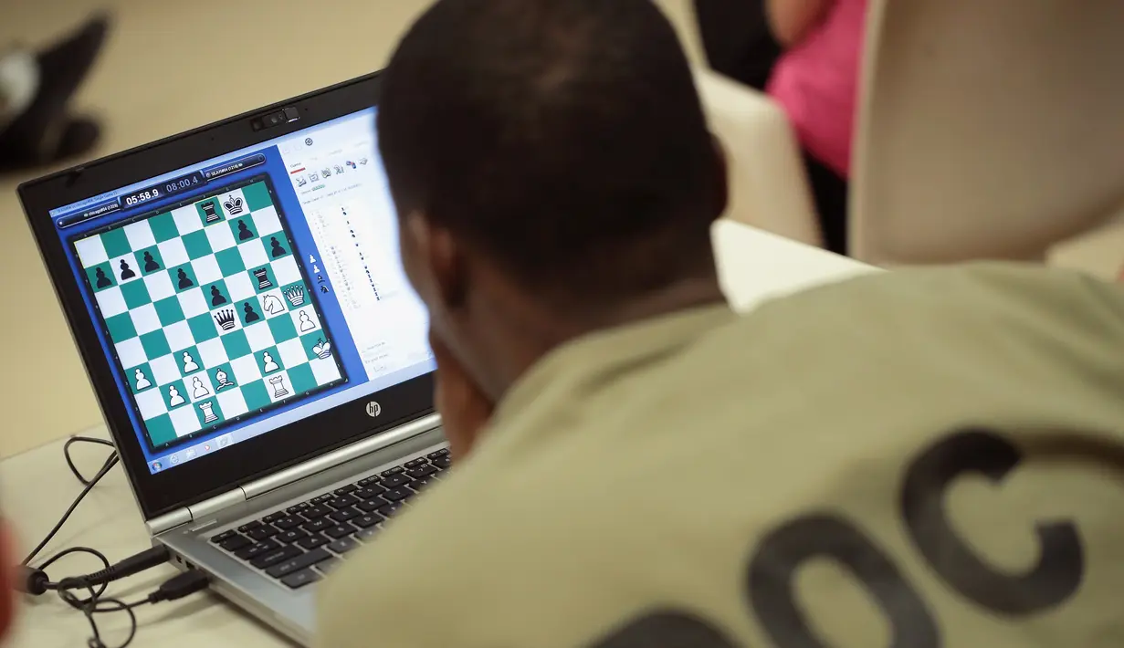Seorang narapidana Cook County serius memperhatikan laptop saat bertanding catur melawan Penjara Viana dari Brasil di Chicago, Illinois (17/5). Ini ketiga kalinya kompetisi catur internasional untuk para narapidana digelar. (Scott Olson/Getty Images/AFP)