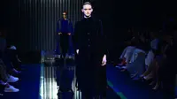 Seorang model memeragakan busana Giorgio Armani untuk koleksi Fall/Winter 2022/2023 pada hari keenam Milan Fashion Week di Milan pada 27 Februari 2022. (MIGUEL MEDINA / AFP)