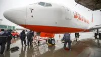 Mekanik maskapai Jeju Air mengikat sebuah pesawat di landasan saat Topan Hinnamnor bergerak menuju Semenanjung Korea di Bandara Internasional Gimpo di Seoul, Korea Selatan, Senin (5/9/2022). Hembusan angin dan hujan lebat dari Topan Hinnamnor diperkirakan mencapai hingga 290 kilometer (180 mil) per jam. (Korea Pool/Yonhap via AP)