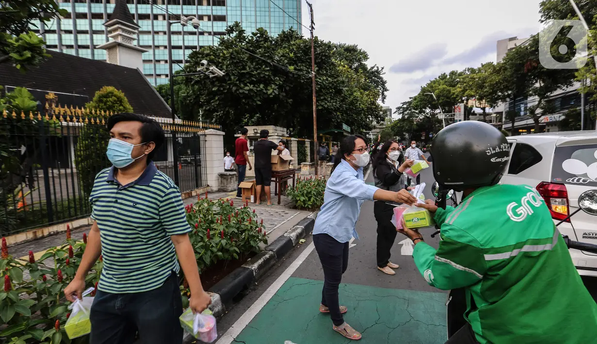 Jemaat membagikan takjil kepada masyarakat menjelang buka puasa di Gereja GPIB Effatha, Jakarta, Rabu (20/4/2022). Momen menjelang buka puasa Ramadhan digunakan jemaat GPIB Effatha berbagi takjil gratis untuk kaum Muslimin di Jalan Melawai, tepatnya di depan gereja itu. (Liputan6.com/Johan Tallo)