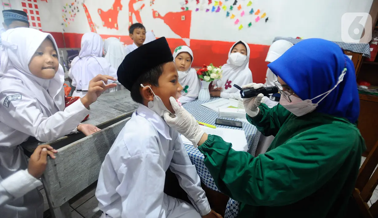 Paramedis Puskesmas Cinere memeriksa kesehatan gigi murid kelas III di SDI Al Hidayah, Cinere, depok, Senin (12/9/20222). Selain pemeriksaan gigi, telinga, dan kuku yang dilakukan periodik 6 bulan sekali  juga dilakukan penyuluhan kesehatan dan pemberian obat cacing kepada anak-anak.
(merdeka.com/Arie Basuki)