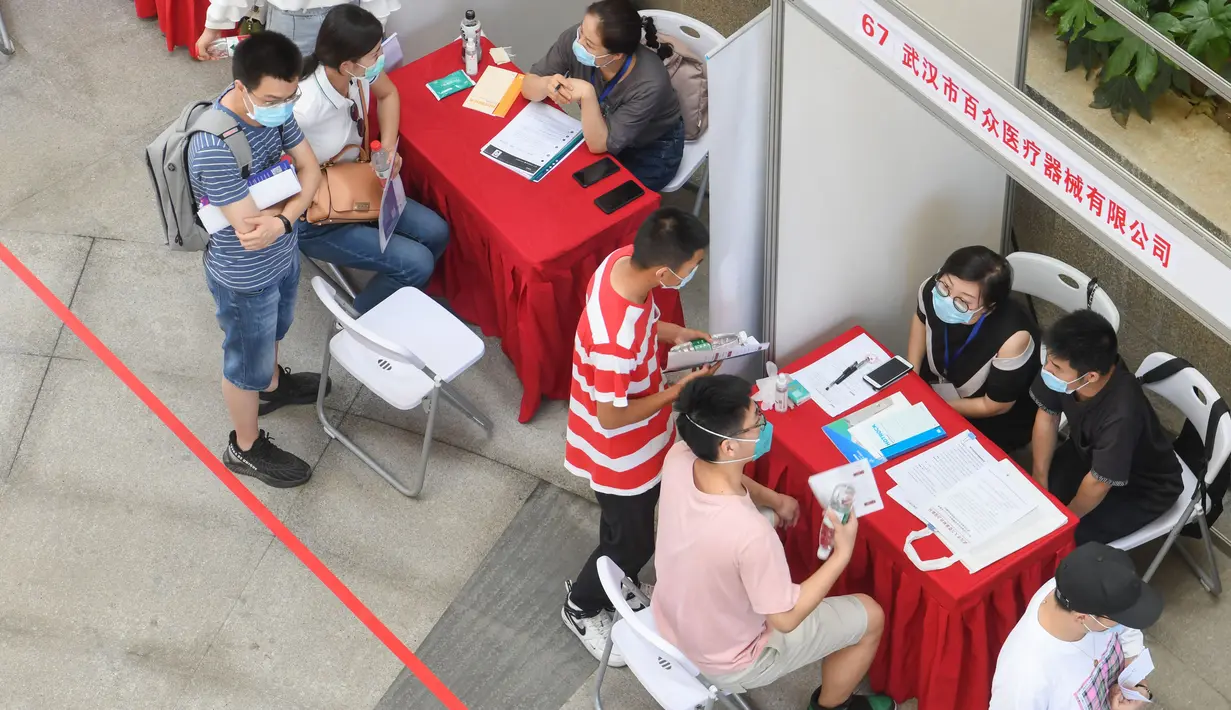 Pencari kerja melakukan wawancara dengan sejumlah perusahaan dalam bursa kerja yang digelar di Universitas Jianghan di Wuhan, Hubei, 1 Juni 2020. Lebih dari 80 perusahaan berpartisipasi dalam bursa kerja luring pertama bagi para lulusan setelah pandemi covid-19 mereda di Wuhan. (Xinhua/Cheng Min)