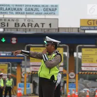 Polisi dan petugas Dishub berjaga di depan Gerbang Tol Bekasi Barat 1, Bekasi, Jabar, Senin (12/3). Ganjil genap ini merupakan kebijakan untuk mengurai kemacetan parah di tol Cikampek-Jakarta, khususnya ruas Bekasi-Jakarta. (Liputan6.com/Arya Manggala)