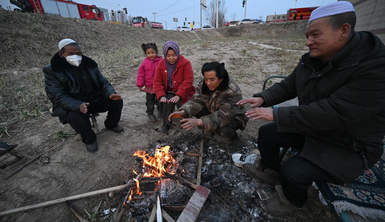 Kompor luar ruangan dan selimut yang diselamatkan dari rumah mereka sebagai satu-satunya sumber kehangatan. (Pedro Pardo / AFP)