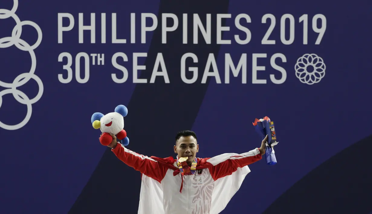 Lifter Eko Yuli melakukan selebrasi saat mendapatkan medali emas SEA Games 2019 cabang angkat besi nomor 61 kg di Stadion Rizal Memorial, Manila, Minggu (1/12). Dirinya meraih emas dengan total angkatan 309 kg. (Bola.com/M Iqbal Ichsan)