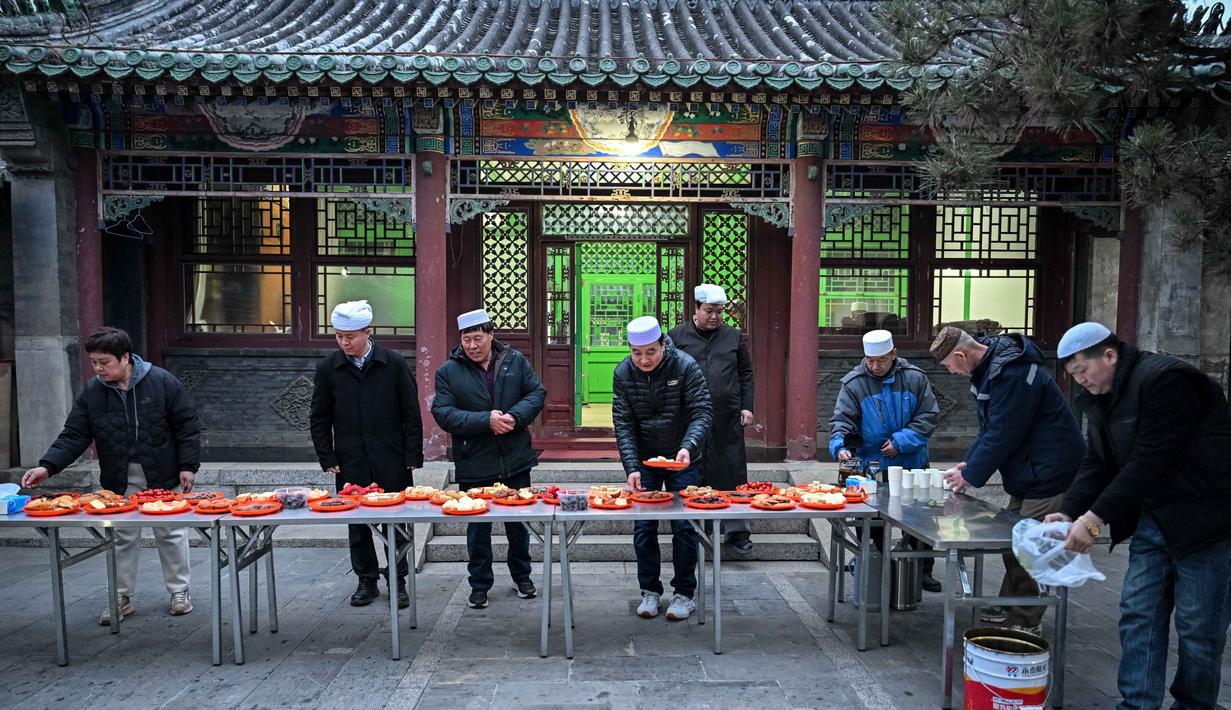 Meski hidup sebagai minoritas, etnis Hui menjaga tradisi keagamaan dengan kuat sambil tetap berasimilasi dengan budaya lokal. Tampak dalam foto, warga Muslim etnis Hui Tiongkok bersiap berbuka puasa di sebuah masjid selama minggu terakhir bulan suci Ramadhan di Beijing pada 17 Maret 2026. (Adek BERRY/AFP)