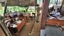 Sejumlah murid SDN Mutiara mengikuti aktivitas belajar di dalam tenda darurat di Kampung Pasir Bayur, Cibeber II, Bogor, Selasa (3/4). Di sekolah itu, hanya tersisa 2 ruangan yang dipergunakan bagi kelas 6 dan ruangan guru. (Merdeka.com/Arie Basuki)