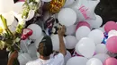Anggota keluarga menempatkan balon dan rangkaian bunga di kuburan korban pembunuhan Fatima yang berusia 7 tahun di Mexico City 1(8/2/2020). Jasad Fatima ditemukan terbungkus tas dan ditinggalkan di daerah pedesaan pada hari Sabtu. (AP Photo/Marco Ugarte)