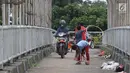 Pengendara motor melintas di samping anak-anak yang bermain di JPO kawasan Cikunir, Bekasi Barat, Senin (12/3). JPO bukan lagi dipenuhi oleh pejalan kaki, tapi berubah fungsi menjadi lahan bermain dan jalan pintas pemotor. (Liputan6.com/Arya Manggala)