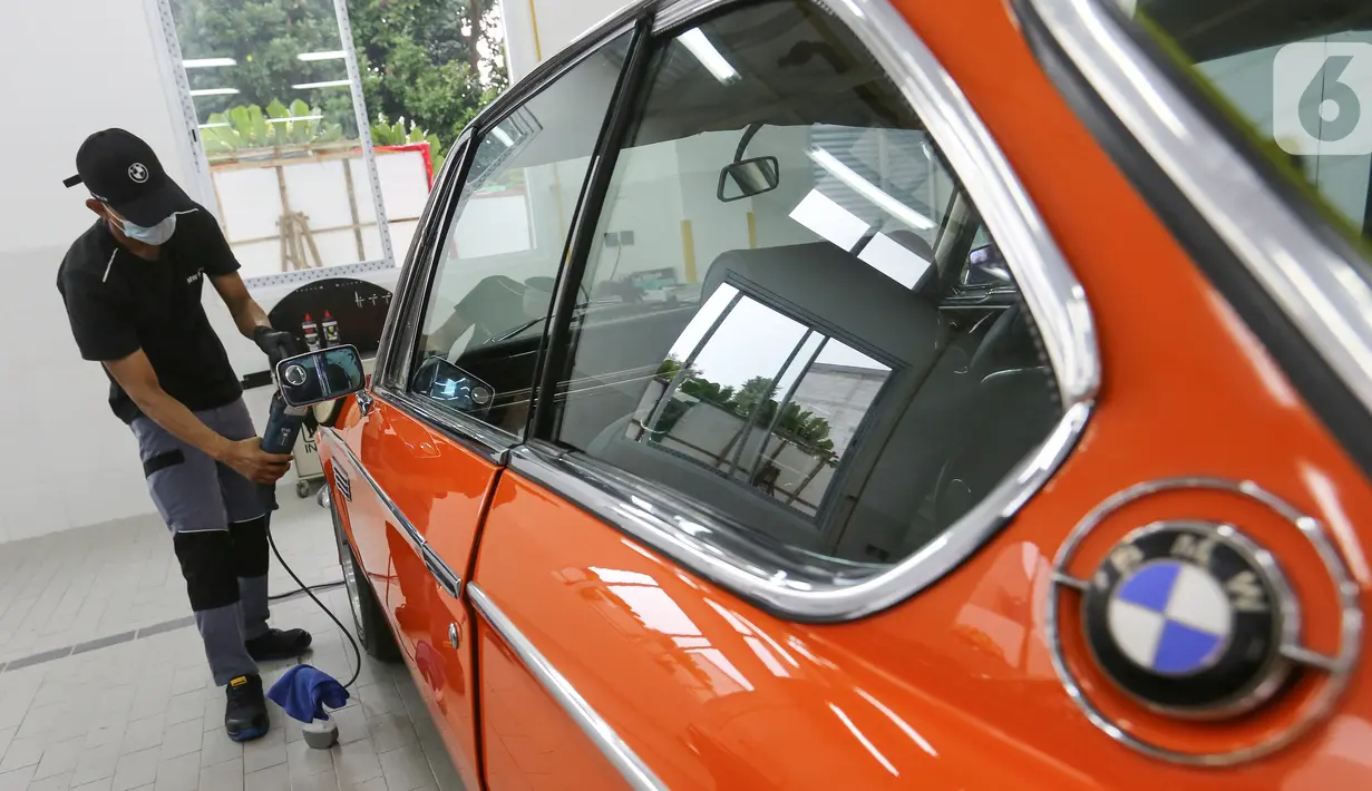 Teknisi memoles mobil di sela-sela pembukaan BMW Ultima, di Tangerang Selatan, Rabu (16/03/2022). BMW Ultima tidak hanya melayani khusus untuk kendaraan BMW dan MINI, namun juga dapat menangani kendaraan premium. (Liputan6.com/Fery Pradolo)  