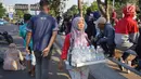 Seorang pedagang minum berjualan di jalan tol dalam kota yang berada di depan Gedung DPR RI, Jakarta, Senin (30/9/2019). Adanya aksi unjuk rasa di sekitar lokasi dimanfaatkan para pedagang asongan untuk mencari rezeki. (Liputan6.com/Immanuel Antonius)