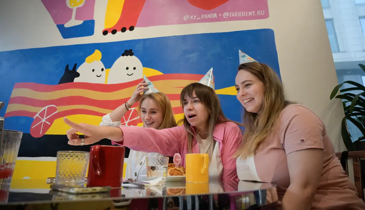 <p>Gadis-gadis merayakan ulang tahun di sebuah kafe di Moskow, pada 12 April 2022. Jauh dari konflik di Ukraina, musim semi telah tiba di Moskow dengan di permukaan setidaknya kehidupan tampak berjalan seperti biasa. Dengan akan segera berakhirnya musim dingin keras yang terkenal di Rusia, orang-orang Moskow memadati restoran dan teater, berkeliaran di galeri seni dan berjalan-jalan di bawah sinar matahari. (Natalia KOLESNIKOVA / AFP)</p>