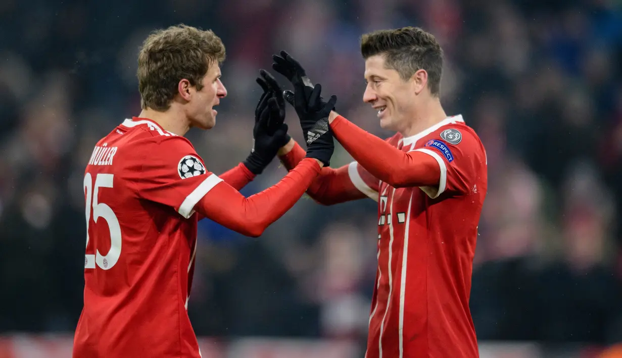 Pemain Bayern Munchen, Robert Lewandowski berselebrasi dengan Thomas Mueller usai mencetak gol ke gawang Besiktas pada pertandingan pertama babak 16 besar Liga Champions di Allianz Arena, Selasa (20/2). Bayern menang telak 5-0. (Matthias Balk/dpa via AP)