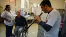 Pasien dan perawat menonton penampilan salah seorang relawan dari Musica Para el Alma di Rumah Sakit Alvarez di Buenos Aires, Argentina (12/6). Dibentuk lima tahun lalu, Musica Para el Alma kini beroperasi di 10 negara.  (AFP Photo/Eitan Abramovich)