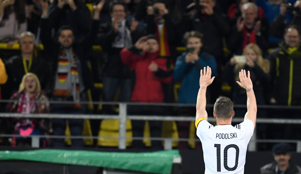 Gelandang Jerman, Lukas Podolski, melambaikan tangan ke suporter usai laga persahabatan kontra Inggris di Stadion Signal Iduna Park, Jerman, Rabu, (22/03/2017). Pertandingan tersebut adalah laga terakhir Podolski bersama Jerman. (AFP/ Marius Becker)