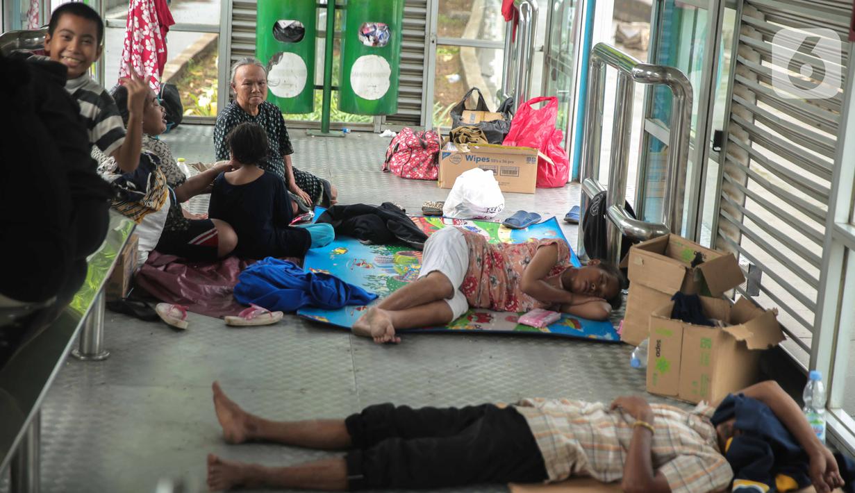 Korban banjir mengungsi di Halte Transjakarta Dispenda Samsat Barat, Jakarta Barat, Jumat (3/1/2020). Para korban terpaksa mengungsi ke halte tersebut akibat kurangnya posko pengungsian di sekitar lokasi terdampak banjir. (Liputan6.com/Faizal Fanani)