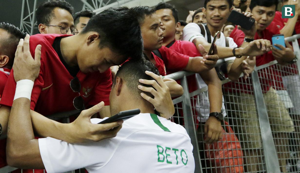 Seorang suporter memeluk striker Timnas Indonesia, Beto Goncalves, usai dikalahkan Singapura pada laga Piala AFF di Stadion Nasional, Singapura, Jumat (9/11). Singapura menang 1-0 atas Indonesia. (Bola.com/M. Iqbal Ichsan)