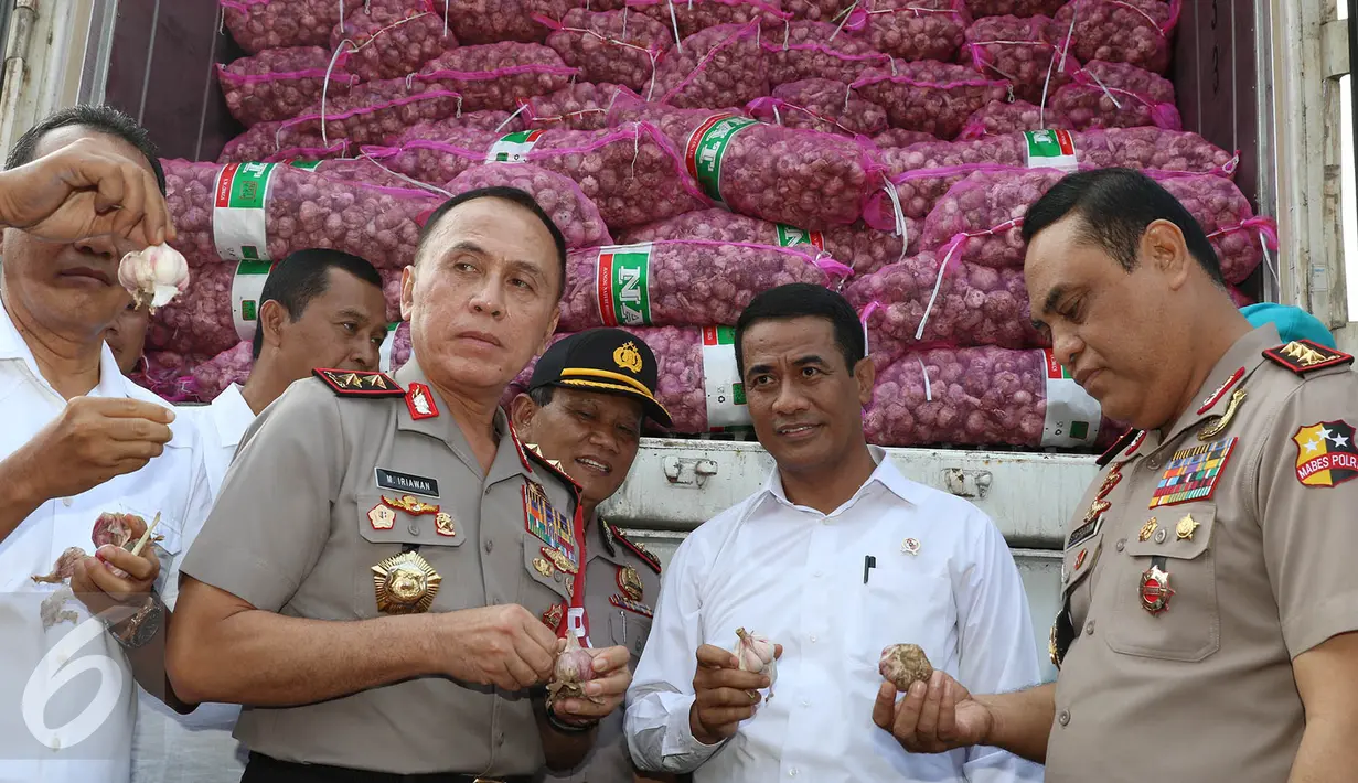 Menteri Pertanian Amran Sulaiman memperlihatkan bawang putih yang diimpor dari Tiongkok saat operasi pasar di Pasar Induk Kramat Jati, Rabu (17/5). Sebanyak 9.000 ton bawang putih dijual dengan harga Rp 25 ribu per kg. (Liputan6.com/Immanuel Antonius)