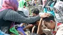Anggota Kwarnas Gerakan Pramuka menangis sambil membasuh kaki ibunya di Taman Wiladatika Cibubur, Jakarta, Rabu (21/12). Memperingati Hari Ibu 2016, Kwarnas Gerakan Pramuka menggelar kegiatan "Membasuh Kaki Ibu" secara massal . (Liputan6.com/Yoppy Renato)