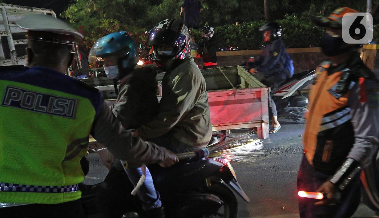 Petugas kepolisian saat menghalau pemudik yang lawan arus di Jalan Kedungwaringin, Kabupaten Bekasi, Jawa Barat, Minggu (9/5/2021). Pemudik memblokir jalan saat penyekatan di posko penyekatan mudik di Kedungwaringin. (Liputan6.com/Herman Zakharia)
