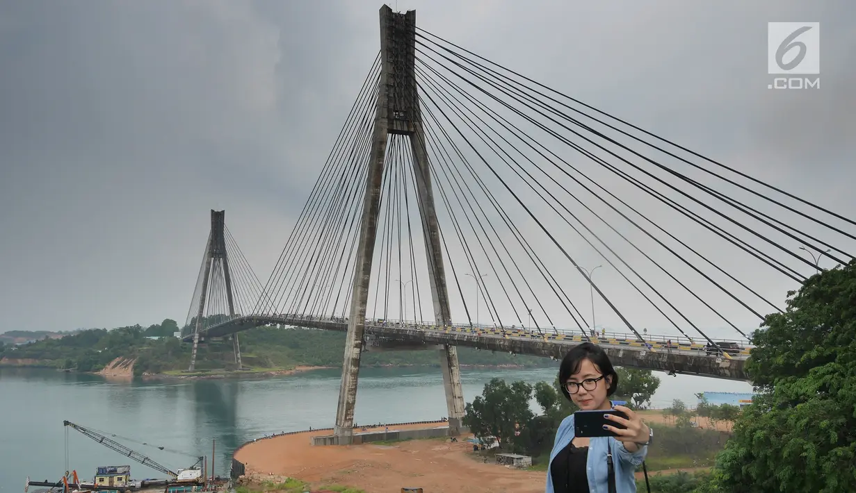 Wisatawan berswafoto dengan latar belakang jembatan Barelang di Batam, Kepri (15/4). Jembatan Barelang adalah singakatan dari Batam, Rempang, dan Galang. (Liputan6.com/Herman Zakharia)