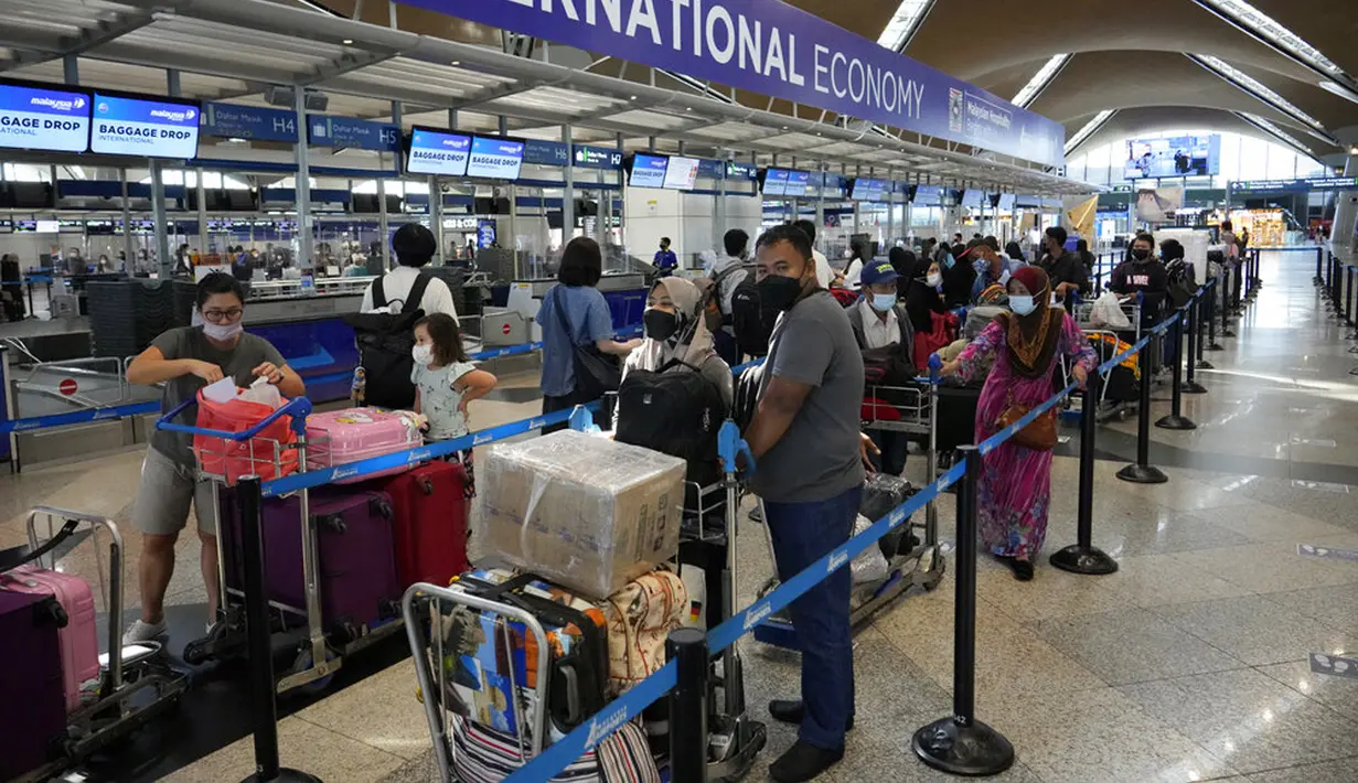 <p>Pelancong mengantre di konter check-in Bandara Internasional Kuala Lumpur, Sepang, Malaysia, Jumat (1/4/2022). Mulai hari ini, Malaysia membuka perbatasannya untuk orang asing dan pelancong yang sudah divaksin COVID-19 lengkap tanpa harus menjalani karantina. (AP Photo/Vincent Thian)</p>
