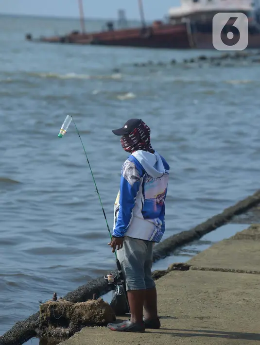 Warga mancing di tepi pantai pelabuhan kali Adem Muara Angke, Jakarta, Sabtu (18/4/2021). Bulan Ramadhan pada kesempatan ini walau di tengah masa pandemi Covid-19 warga yang memancing ikan sambil menunggu waktu berbuka puasa. (merdeka.com/Imam Buhori)