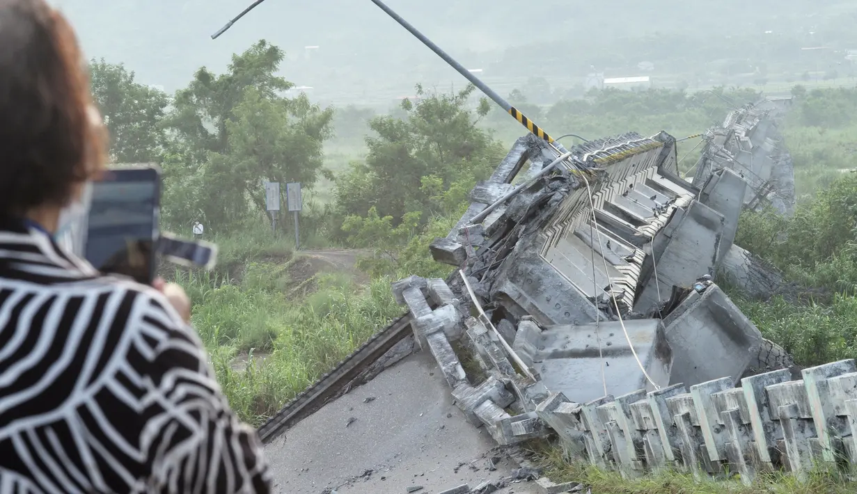 Seorang penduduk mengambil foto jembatan Kaoliao yang runtuh di daerah Hualien Taiwan timur (19/9/2022). Pusat Seismologi Taiwan mencatat gempa pada Minggu berada di kedalaman 7 kilometer di sebelah utara Kabupaten Taitung. (AFP/Sam Yeh)