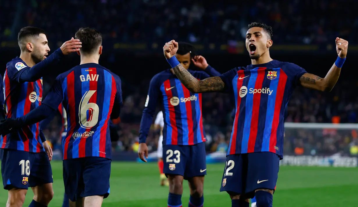 Selebrasi pemain Barcelona, Raphinha (kanan) bersama rekannya setelah memenangkan pertandingan pekan ke-20 La Liga 2022/2023 melawan Sevilla yang berlangsung di Camp Nou, Senin (6//2/2023). (AP Photo/Joan Monfort)