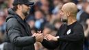 Manajer Liverpool, Jurgen Klopp (kiri) berjabat tangan dengan manajer Manchester City, Pep Guardiola setelah pertandingan Liga Inggris antara Manchester City dan Liverpool di Etihad Stadium, 10 April 2022. (AFP/Paul Ellis)