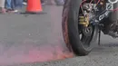 Ban seorang freestyler mengeluarkan asap saat melakukan atraksi freestyle sepeda motor dalam Festival Damai Millenial Road Safety di Monas, Jakarta, Minggu (23/6/2019). Festival ini menyosialisasikan disiplin berlalu lintas serta merajut persatuan dan kesatuan. (merdeka.com/Iqbal Nugroho)