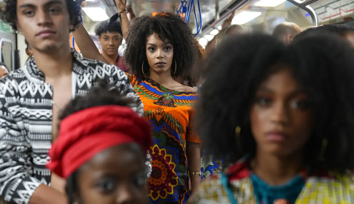Model mengenakan pakaian yang dirancang oleh siswa dari komunitas Afro-Brasil jelang Hari Kesadaran Kulit Hitam dalam stasiun kereta bawah tanah di Sao Paulo, Brasil, 19 November 2021. November diakui sebagai Bulan Kesadaran Kulit Hitam. (AP Photo/Andre Penner)