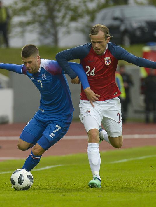 Duel pemain Islandia, Johann Berg Gudmundsson (kiri) dan pemain Norwegia, Iver Fossum pada laga uji coba di Reykjavik, Islandia, (2/6/2018). Islandia kalah dari Norwegia 2-3. (AFP/Haraldur Gudjonsson)