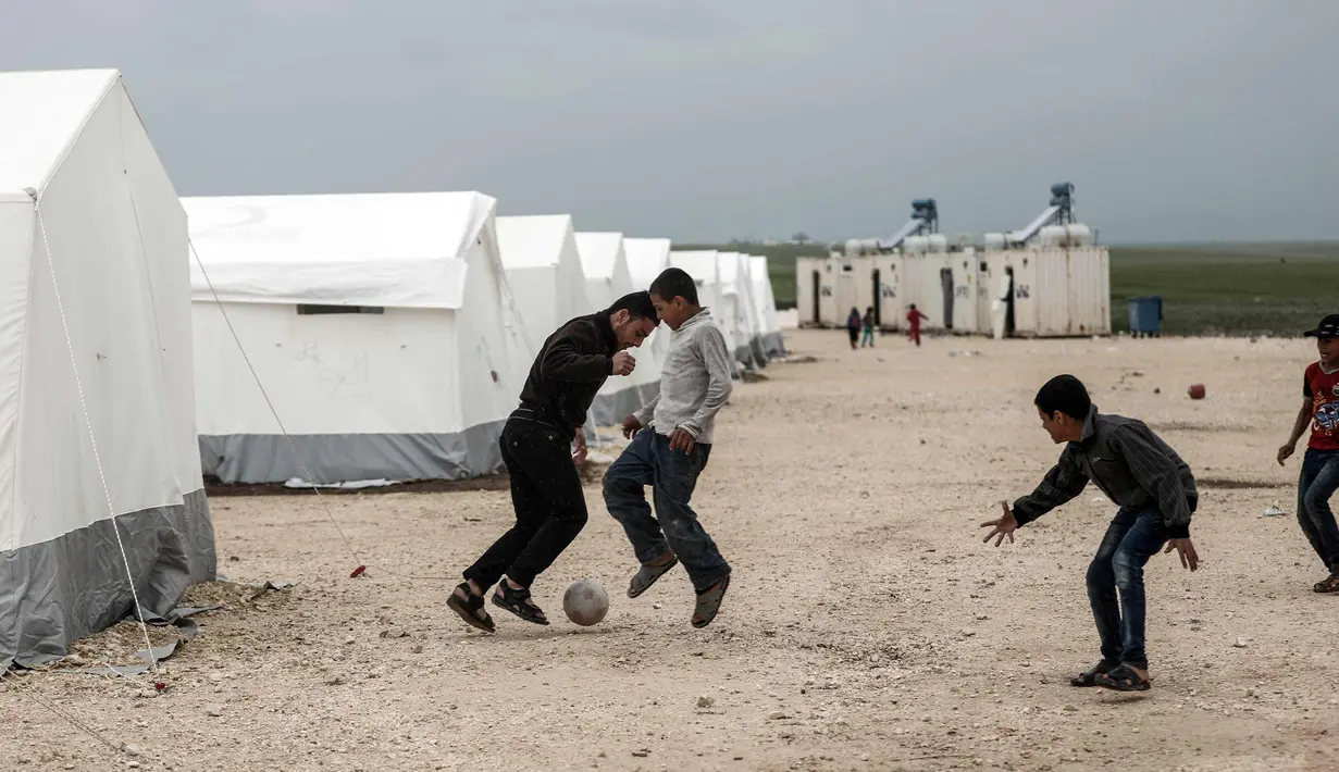 Sejumlah anak pengungsi Suriah bermain sepak bola di sebuah kamp di al-Bil, timur dari kota Azas yang dikuasai pemberontak di Suriah utara (21/4). (AFP Photo/Sameer Al-Doumy)