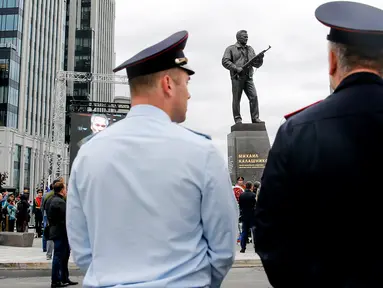 Petugas polisi berjaga-jaga saat upacara peresmian patung Mikhail Kalashnikov di pusat kota Moskow, Rusia (19/9). Mikhail Kalashnikov merupakan penemu senapan serbu AK-47. (AFP Photo/Maxim Zmeyev)