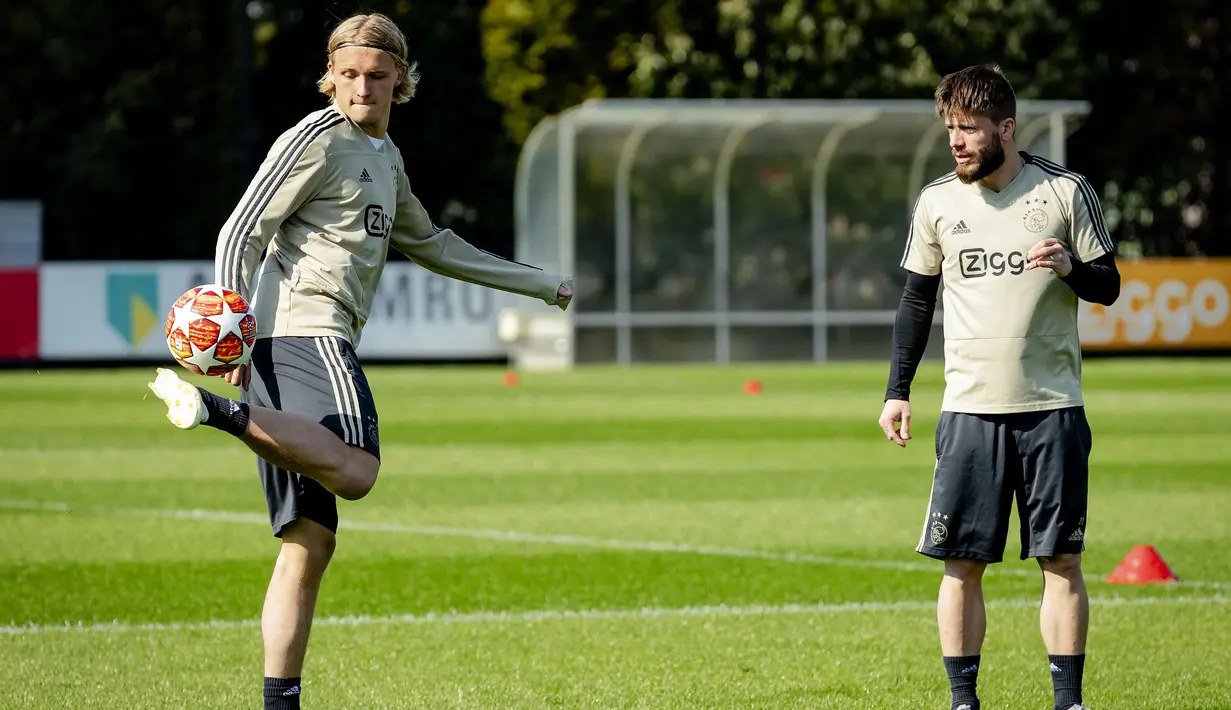 Pemain Ajax Amsterdam, Kasper Dolberg (kiri) dan Lasse Schone mengikuti sesi latihan tim di Sports park De Toekomst, Belanda (9/4). Ajax akan bertanding melawan wakil Italia Juventus pada leg pertama babak perempatfinal Liga Champions di Johan Cruyff Arena. (AFP Photo/ANP/Robin van Lonkhuijsen)