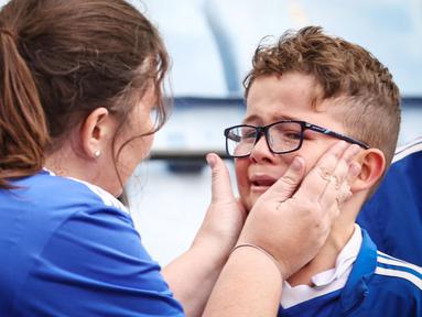 Suporter cilik Leicester City menangis setelah menyaksikan laga melawan West Ham United pada laga Liga Inggris di Stadion King Power, Minggu (28/5/2023). The Foxes resmi degradasi setelah mengakhiri musim di urutan 18 klasemen akhir dengan 34 poin. (AFP/Darren Staples)
