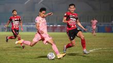 Pemain Madura United, Haris Tuharea (tengah) melepaskan tendangan dibayangi pemain Bali United, Komang Tri Arta dalam laga pekan ke-16 BRI Liga 1 2021/2022 di Stadion Sultan Agung, Bantul, Kamis (09/12/2021). (Bola.com/Bagaskara Lazuardi)
