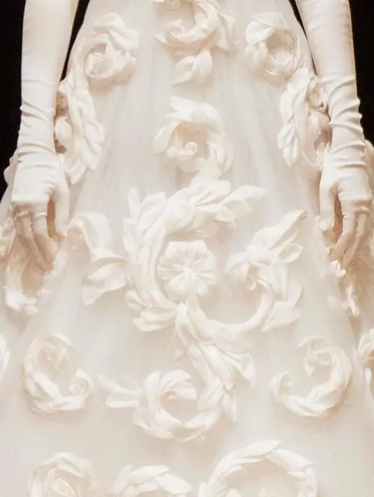 Gaun lengan pendek itu hadir dengan detail sulaman rumit berbentuk pusaran besar tiga dimensi, serta ekor panjang menyapu lantai.  [Foto: IG/queenrania/beautyinsideout.v].