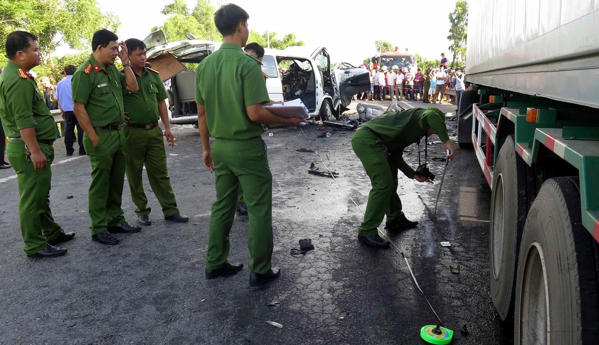 Petugas memeriksa lokasi kecelakaan sebuah van yang membawa rombongan pengantin dengan truk kontainer di Quang Nam, Vietnam, Senin (30/7). 14 orang dalam satu keluarga termasuk pengantin pria tewas seketika. (Do Van Truong/Vietnam News Agency via AP)