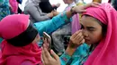 Aksi peserta saat merias wajah dengan mata tertutup di Kantor Balai Kota Tangerang Selatan, Banten, Jumat (27/4). Perlombaan ini diikuti oleh 400 peserta. (Merdeka.com/Arie Basuki)