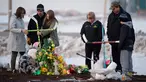 Sebuah keluarga menempatkan salib yang terbuat dari tongkat hoki untuk memberi penghormatan kepada korban kecelakaan bus yang membawa tim hoki es Humboldt Broncos di Provinsi Saskatchewan, Kanada (9/4). (Jonathan Hayward/The Canadian Press via AP)