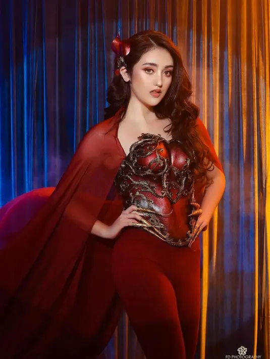 Tampil serba merah, Ranty Maria tetap menunjukkan sisi imutnya dalam balutan breastplate Crimson Red, dipadukan dengan celana panjang, dan jubah warna senada. Penampilannya disempurnakan dengan earcuff dari Ikie Morphacio. (Instagram/morphaciobodyart).