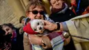 Seorang pendeta memberkati anjing saat upacara Saint Anthony di Madrid, Spanyol, Selasa (17/1). Saint Anthony adalah orang suci yang dianggap sebagai pelindung hewan di Gereja Katolik. (AP Photo / Daniel Ochoa de Olza)
