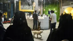 Pemilik anjing memesan di kafe "Barking Lot" di kota pesisir Khobar, Arab Saudi pada 25 September 2020. Pemilik anjing di Arab Saudi kini dapat menikmati secangkir kopi bersama hewan kesayangan mereka di kafe baru, sekaligus yang pertama di negara konservatif itu. (FAYEZ NURELDINE/AFP)