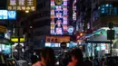 Pejalan kaki berjalan di depan neon sign dari 'Tsui Wah Restaurant' di Hong Kong (16/4). Kota Hong Kong  tidak pernah benar-benar kehilangan kegelapannya berkat cahaya 24 jam dari segudang neon sign. (AFP Photo/Philip Fong)