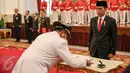 Presiden Joko Widodo (kanan) menyaksikan pendandatanganan dokumen pelantikan Rano Karno sebagai Gubernur Banten di Istana Negara, Jakarta, Rabu (12/8/2015). Rano menggantikan Ratu Atut yang dipidana dalam kasus korupsi. (Liputan6.com/Faizal Fanani)